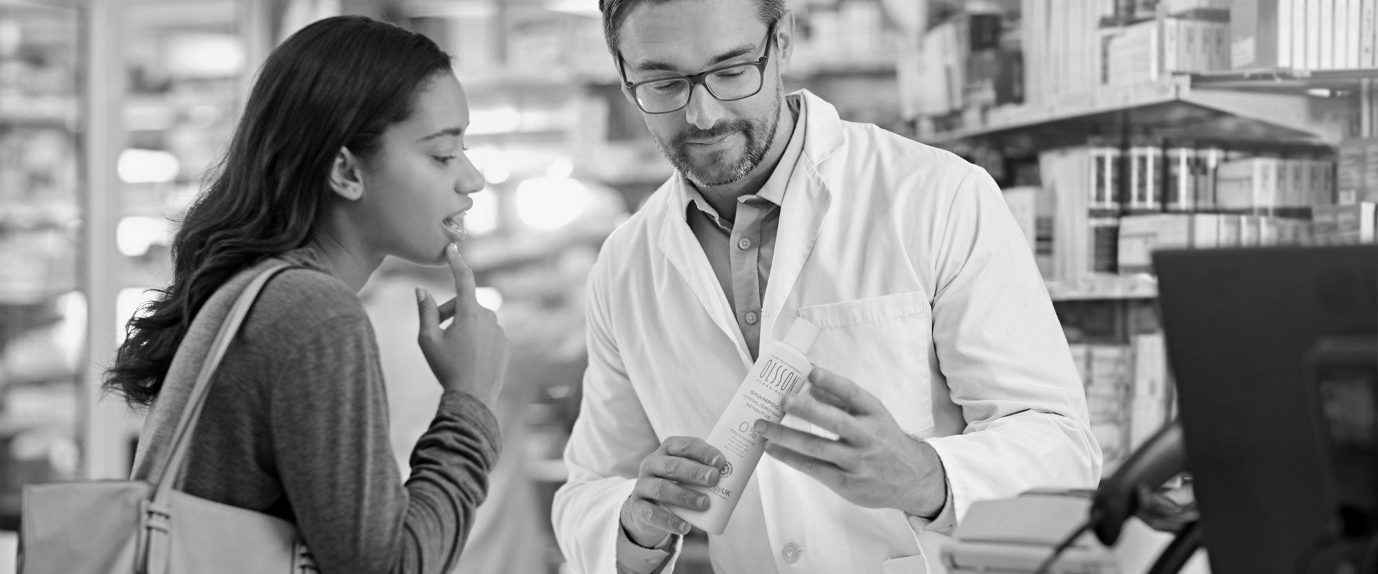 A Pharmacist Offers Allergy UK Approved Olsson Shampoo to a Customer seeking a solution for a Sensitive Scalp.