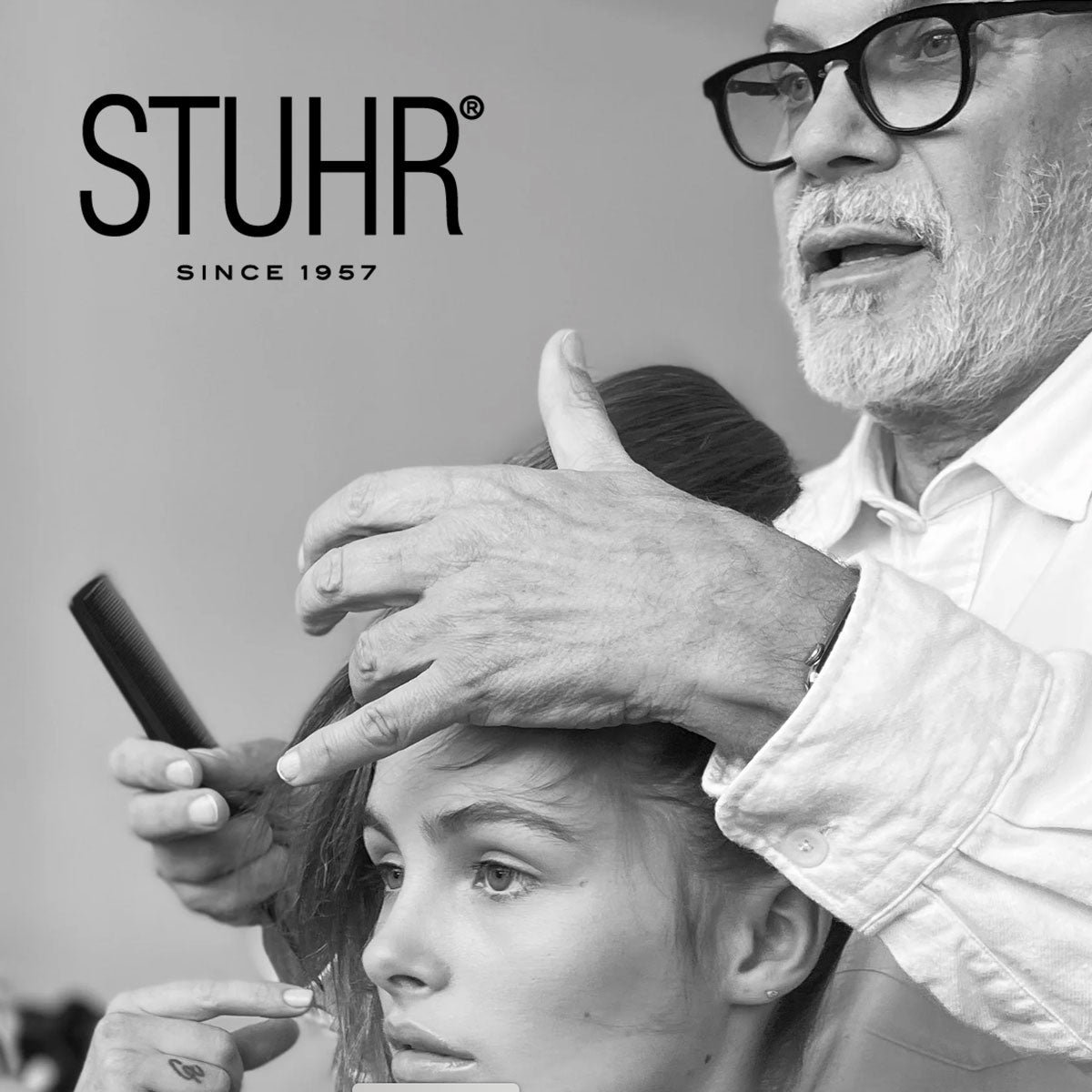 Black and white photo of a hairdresser cutting a woman's hair with 'STUHR' branding.
